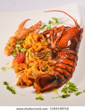 Spaghettoni with Maine lobster and Bisque sauce on white plate