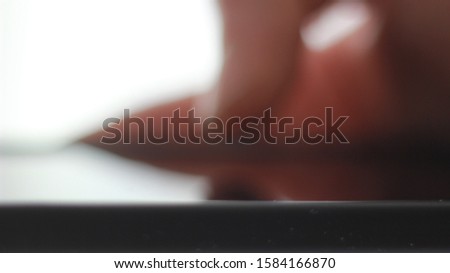 Macro of male finger browsing on smartphone screen.