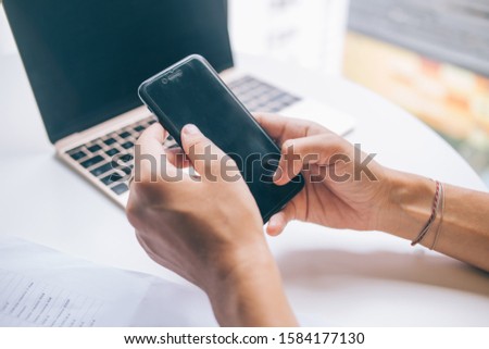 Cropped image of skilled female typing contact number on cellphone keyboard during remote work, millennial woman watching web video vlog via mobile gadget connecting to public wifi internet