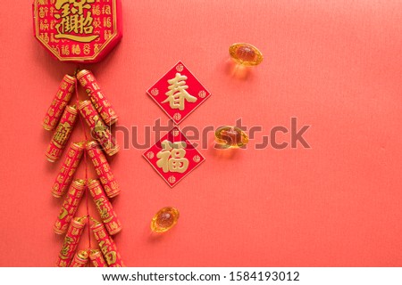 Chinese firecrackers and Chinese gold ingots (foreign meaning blessing, prosperity, fortune, spring，auspicious) and red envelopes and decorated with fresh oranges on Red Paper background