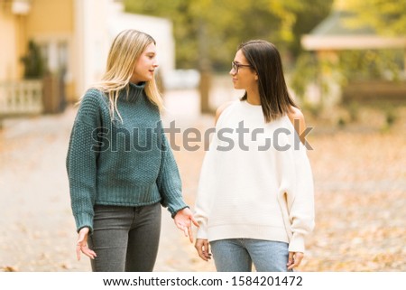 Two young woman walking in the park