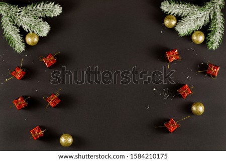 Group of christmas gifts with ribbons, golden christmas balls and snowy sprigs of pine isolated on black background.