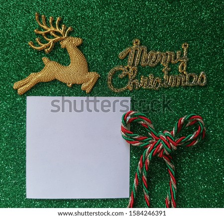 Creative Merry Christmas background with word, bow tie, deer and white blank paper for text. 