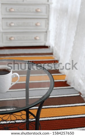beautiful bright balcony interior with striped carpet and grey sofa