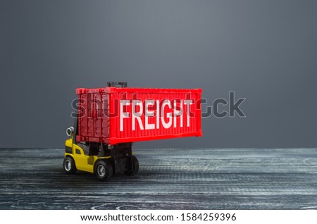 Yellow forklift carries red freight container. Transportation logistics infrastructure, import and export of goods and products. Warehousing. Cargo transit. Powerful economy, world globalization
