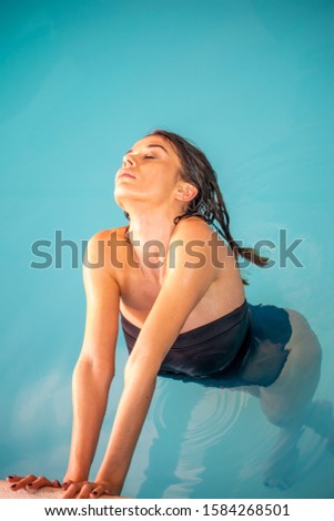 Beautiful woman in the pool relaxing and refreshing.