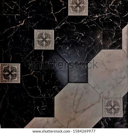 Black and white ceramic tiles with geometric pattern for wall and floor decoration. Concrete stone surface background. Texture for interior design project.