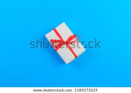 Gift box with ribbon and bow on color background and space for text. Top view