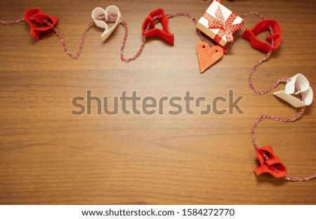 Valentine's Day, February 14th. Red and white heart on a wooden background. With candles and a red silk ribbon. Present. 