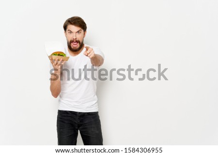 man gesturing with hands hamburger in hand on an isolated background cropped view