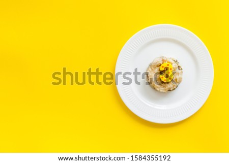 Cat's birthday concept. Pet feed with festive candle in shape of three on yellow background top-down copy space