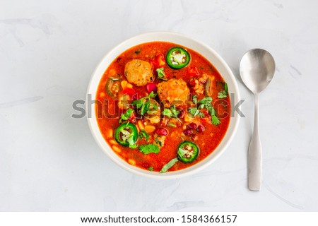Hot Soup with Meatballs and vegetables in a Bowl with a Spoon on the Table. Winter Food, Albondigas Soup, Spanish and Mexican Food. Top view. Flat Lay Stock Photo