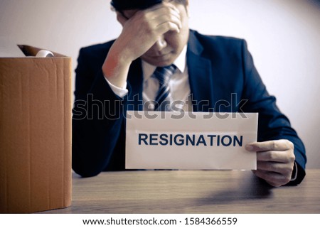 Stressed businessman will prepared being sending resignation letter to company and packing belongings and files into brown cardboard box, changing and resigning from work concept.