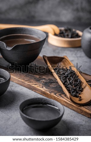 Ceramic tea pot and cups with the famous Photo in the room Chinese tea ceremony on dark background.