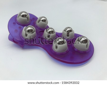 hand massage instrument purple color hand made New alternative massage instrument made of different alternative compositions on white background
