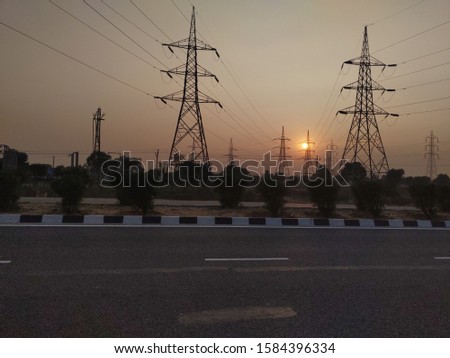 beautiful sunset behind electric towers. national highway.