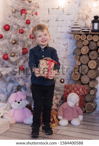 Happy little smiling boy with christmas gift box.