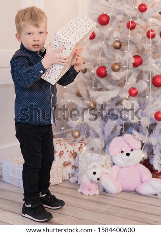 Happy little smiling boy with christmas gift box.