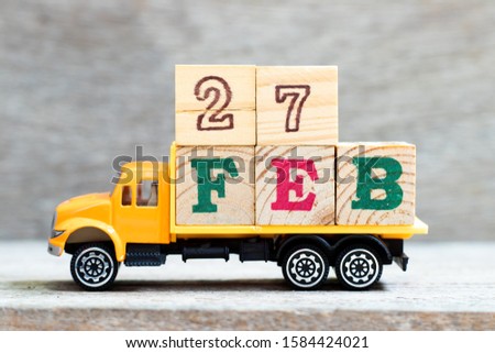 Truck hold letter block in 27word feb on wood background (Concept for date 27 month February)