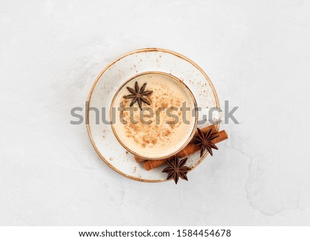 Indian Masala chai tea. Traditional Indian hot drink with milk and spices on white concrete background. Top view, flat lay. Royalty-Free Stock Photo #1584454678