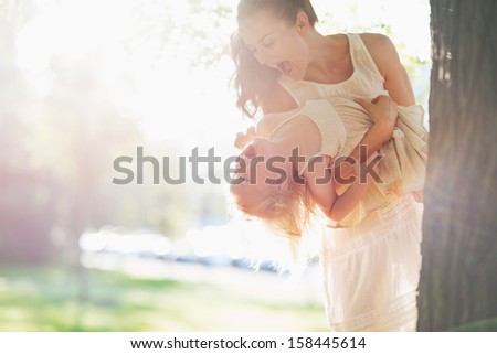 Happy mother and baby having fun near tree Royalty-Free Stock Photo #158445614