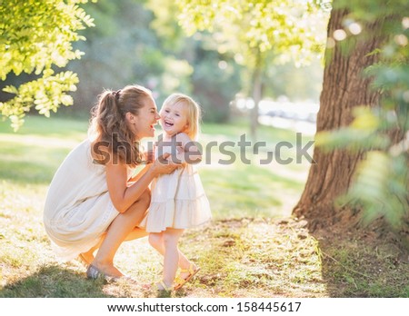 Portrait of happy mother and baby playing outdoors Royalty-Free Stock Photo #158445617