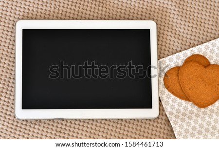 Digital tablet with a blank screen on a gray background. High resolution photography, blank black screen ready to insert graphics or text. View from above.
