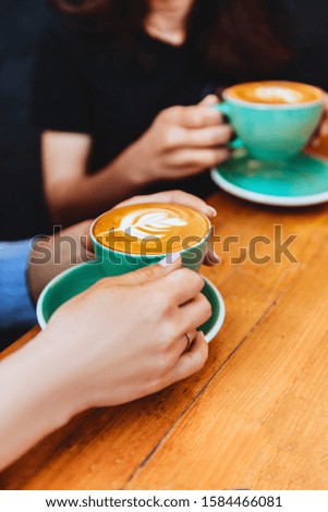 Drinking coffee together. two beautiful woman keeping cups of coffee.