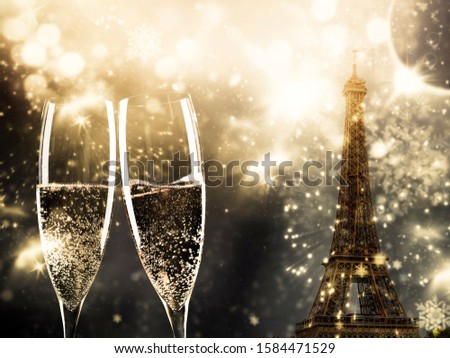 two glasses of champagne and Eiffel tower with fireworks New Year in Paris