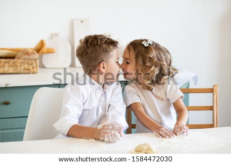 little children kissing in the kitchen at home