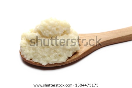 Horseradish sauce in wooden spoon, isolated on white background