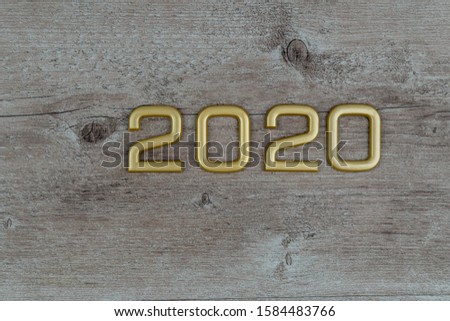 gold 2020 numbers on wooden background.
