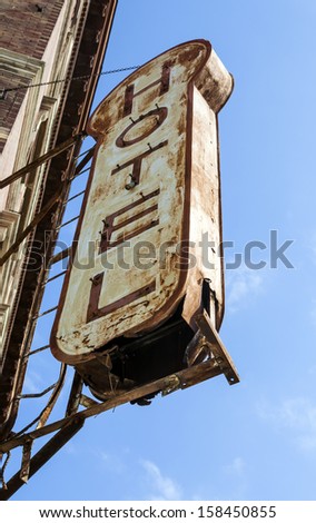 Weathered hotel sign against blue sky