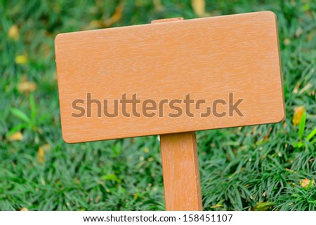 Wooden signboard on grass