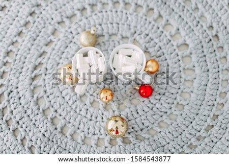 Beautiful Christmas picture. Two white cups of coffee with marshmallow and a few Christmas tree colored balls of toys lie on a delicate textured background.