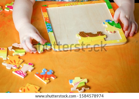 Little beautiful girl collects a picture of a puzzle.  Russian text: fairy