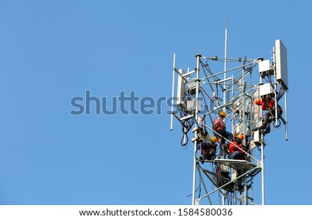 Technician Installing Telecommunication Tower of 4G and 5G cellular. Base Station or Base Transceiver Station. Wireless Communication Antenna Transmitter. Telecommunication tower with antennas  Royalty-Free Stock Photo #1584580036