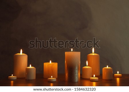 Group of burning candles on black table, space for text
