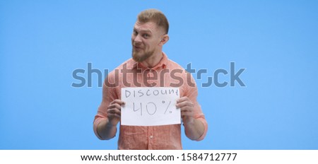 Medium shot of a young man holding a special offer price sign with forty percent discount