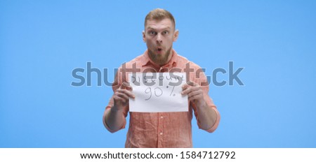 Medium shot of a young man holding a special offer price sign with ninety percent discount