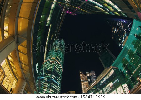 Fish eye lens. Long exposure photography. The exterior of the modern business skyscrapers in autumn night. Buildings of glass and metal. Modern city business lifestyle. 