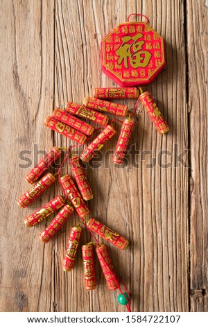 When Chinese New Year, Chinese red firecrackers and Spring Festival couplets are placed on old wooden door panels (Chinese meaning blessing, wealth, auspiciousness)