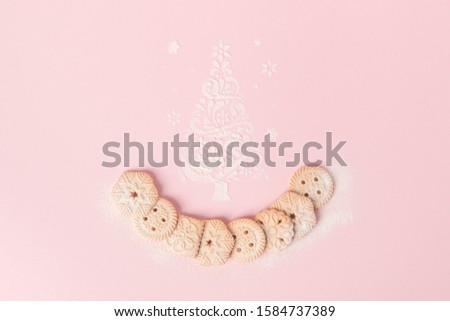 Traditional holiday cookies on bright pink background with sugar powder shaped as Christmas tree. Minimal Happy New Year concept. Top view flat lay image.