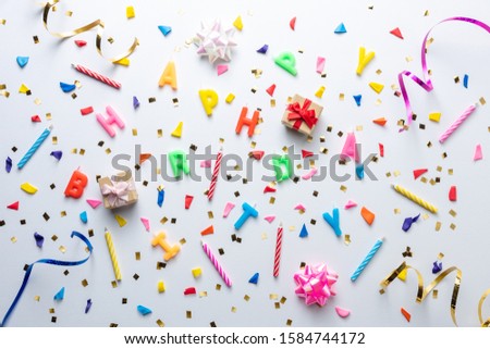 Creative composition made with birthday party things and party streamers on white background. Minimal celebration party concept.