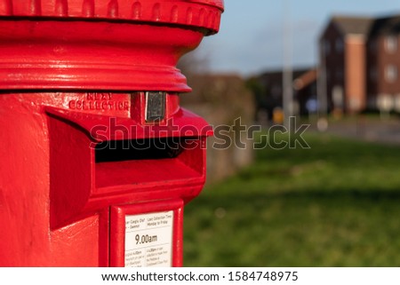 A classic vintage red mailbox for posting letters in a Street in Wales, United Kingdom