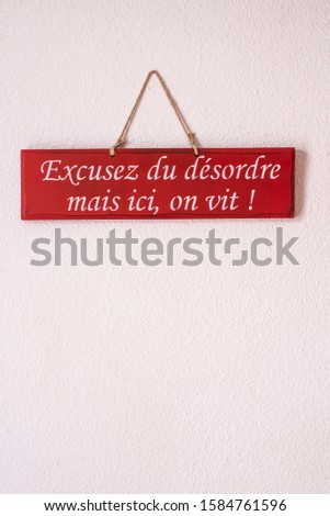 decorative sign with a humorous sentence: "excuse the mess but here, we live !"