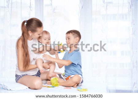 Beautiful young mother plays with two children. family value concept.