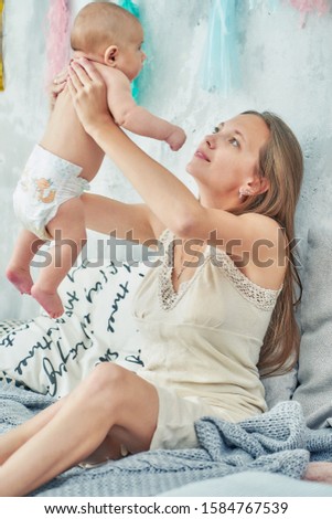 mother and newborn baby are playing. vertical