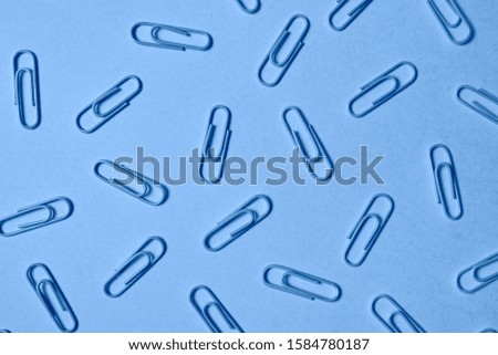 Classic blue background with paper clips pattern, copy space. Color of the year 2020. Top view, flat lay