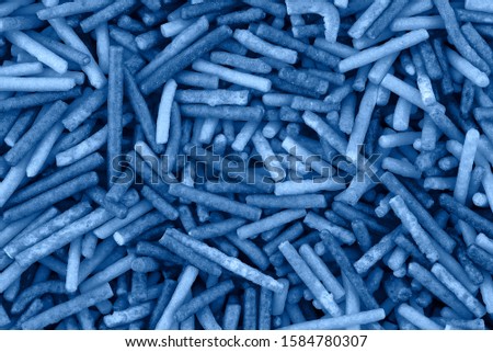 Candy sugar chocolate texture, cake decoration, copy space. Pile of chocolate candies. Classic blue background. Color of the year 2020. Top view, flat lay